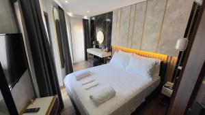 イスタンブールにあるMadrigal Boutıque Hotelの白いシーツと枕が備わったベッドのある寝室