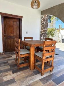 a wooden table with chairs and a wooden door at Casa grande familiar Santuario de Mariana in La Paz