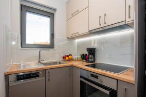 a kitchen with white cabinets and a sink and a window at Filitsa's Luxury House in Chania Town +30 photos