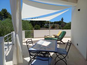 Un patio con una mesa y sillas en un balcón. en Boat dreams , garden relax, en Matino