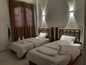 two beds in a hotel room with towels on them at Panorama Hotel in Luxor