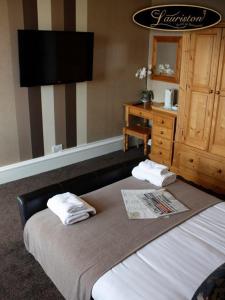 a hotel room with a bed and a dresser at Lauriston Hotel in Ardrossan