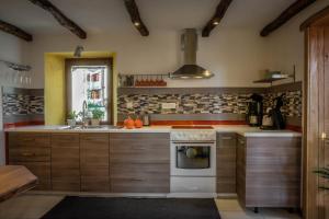 a kitchen with wooden cabinets and a stove top oven at Apartment Kamacir in Kobarid