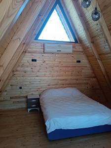 a bed in a wooden room with a window at Çırağan Deluxe BOTANİK Park Bungalov Evleri in Tire