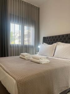 a bed with towels on it with a window at Sofia's House in Nea Moudania +59 photos