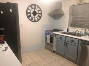 a kitchen with a sink and a clock on the wall at Small Cozy Home in Beverly Hills