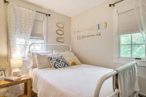 une chambre avec un lit et deux fenêtres dans l'établissement 4 Mi to Bristol Beach Cottage with Pond and Deck, à East Falmouth