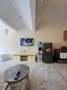 a living room with a table and a tv on the wall at Golden Sun and Sand Studios in Diani Beach