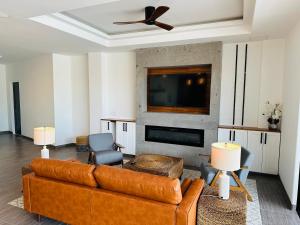 a living room with a couch and a tv at Casa Santos Pedregal in Cabo San Lucas