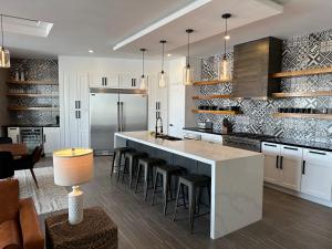 a kitchen with a large island with bar stools at Casa Santos Pedregal in Cabo San Lucas
