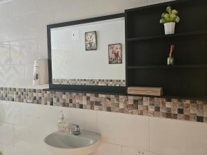 a bathroom with a sink and a mirror at Colisseum Roma - Vive Claro -El cubo movistar campin in Bogotá