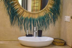 a bathroom with a white sink and a mirror at Maracuja villa Zanzibar in Bwejuu +44 photos
