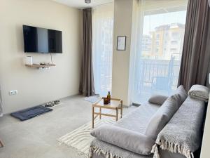a living room with a couch and a large window at Boho and More in Sozopol