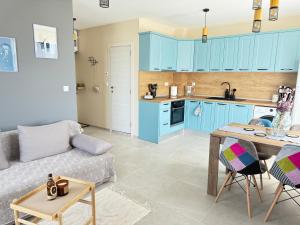 a kitchen and a living room with blue cabinets at Boho and More in Sozopol