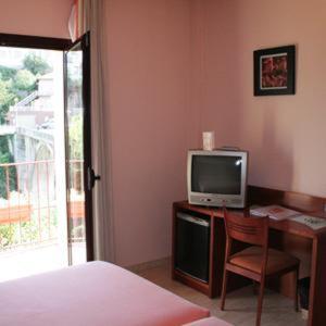 a bedroom with a desk with a tv and a bed at Hotel Sant Quirze De Besora in Sant Quirze de Besora