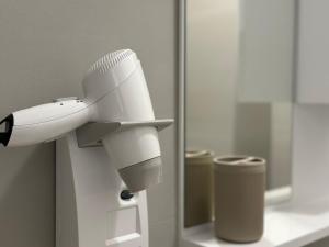 a white hair dryer in front of a mirror at Sublime studio nr3 in Ulcinj +4 photos