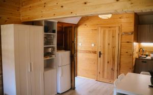 a kitchen with wooden walls and a refrigerator at Domki Marianówka Wieżyca in Potuły