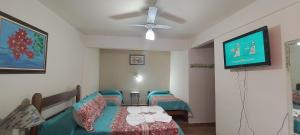 Zimmer mit 2 Betten und einem Deckenventilator in der Unterkunft Hospedagem Vila Rica - 500m do centro de Cunha SP in Cunha