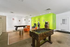 a room with a ping pong table and green walls at 11 Condo-Hotel With Double Bed And Community Pool Miles From Disney! in Kissimmee