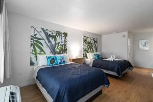 a bedroom with two beds with blue comforters at 11 Condo-Hotel With Double Bed And Community Pool Miles From Disney! in Kissimmee +19 photos