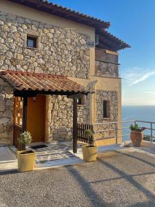 a stone house with a door and a balcony at Villa Sunrise in Agia Paraskevi