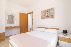 a bedroom with a white bed and a picture on the wall at Gennadi Villa Mare in Gennadi