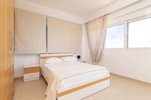 a bedroom with a bed and a large window at Gennadi Villa Mare in Gennadi