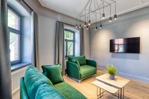 采西斯Apartments Vitenberg的客厅里有一张绿色的沙发和一张桌子