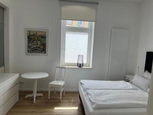 a bedroom with a bed and a table and a window at Apartment Van Eß Hof - Altstadt Warburg in Warburg