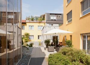 a courtyard with tables and umbrellas next to a building at Hotel Süd Graz in Graz