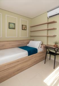 a bedroom with a bed and a table and a chair at PALMAS EXPERIENCE - Apartamento Luxuoso, vista lago, próximo ao shopping in Palmas