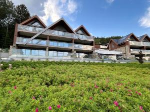 une maison sur une colline avec un champ de fleurs dans l'établissement Kras Resort 304 Szklarska Poręba, à Szklarska Poręba