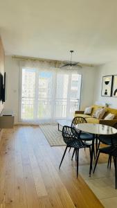 ein Wohnzimmer mit Tisch und Couch in der Unterkunft Bel appartement à 5 mn de Paris très proche Métro 13 et 14 in Saint-Ouen