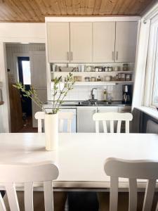 a white kitchen with a white table and chairs at Farm Stay B & B in Annerstad +19 photos