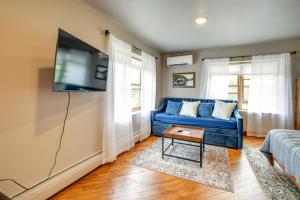 a living room with a blue couch and a tv at Meredith Studio Near Downtown Hike, Swim, Ski! in Meredith +16 photos