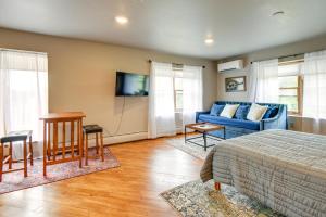 a bedroom with a bed and a blue couch at Meredith Studio Near Downtown Hike, Swim, Ski! in Meredith