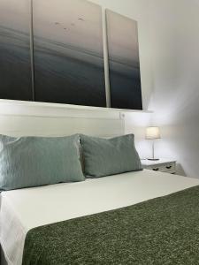 a bedroom with a white bed with two pillows at Casa Agustina in Arguineguín