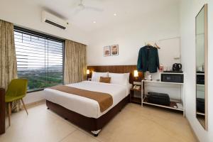 ein Hotelzimmer mit einem Bett und einem Fenster in der Unterkunft Freesia Residency By Express Inn - Navi Mumbai in Navi Mumbai