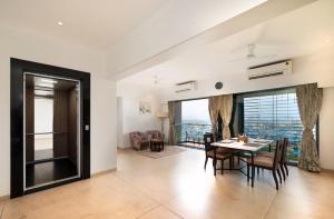 ein Esszimmer mit Tisch und Stühlen und einem Fenster in der Unterkunft Freesia Residency By Express Inn - Navi Mumbai in Navi Mumbai + 36 Fotos