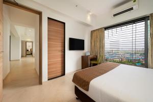 ein Schlafzimmer mit großem Bett und großem Fenster in der Unterkunft Freesia Residency By Express Inn - Navi Mumbai in Navi Mumbai