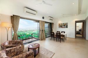 ein Wohnzimmer mit einem Tisch und Stühlen sowie einem großen Fenster in der Unterkunft Freesia Residency By Express Inn - Navi Mumbai in Navi Mumbai