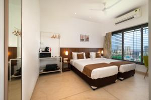ein Schlafzimmer mit großem Bett und großem Fenster in der Unterkunft Freesia Residency By Express Inn - Navi Mumbai in Navi Mumbai