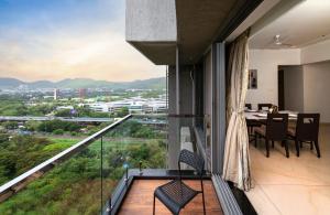 Apartment mit einem Balkon mit Tisch und Stühlen. in der Unterkunft Freesia Residency By Express Inn - Navi Mumbai in Navi Mumbai