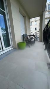Un balcón con una mesa y un banco en un edificio. en Appartement 15 min Paris Gare du Nord, en Deuil-la-Barre