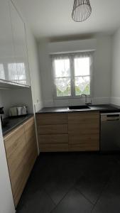 una cocina con fregadero y ventana en Appartement 15 min Paris Gare du Nord, en Deuil-la-Barre