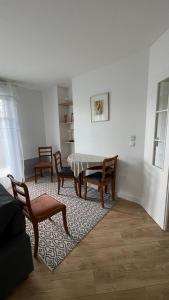 una sala de estar con una mesa y dos sillas en Appartement 15 min Paris Gare du Nord, en Deuil-la-Barre