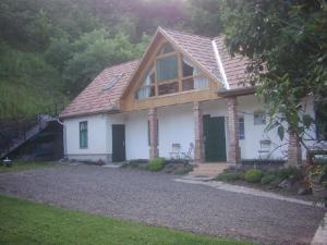 uma pequena casa branca com um telhado de gambrel em Boróka Vendégház em Matrakeresztes