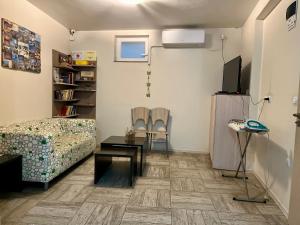 a living room with a couch and a tv at Хостел Атлас - Hostel Atlas in Blagoevgrad