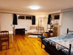 a living room with a bed and a desk and a couch at A place to be - Ruhelage mit gratis Parkplatz in Graz