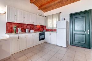 a kitchen with white cabinets and a green door at Etherial Stay in Corfu island Home166 in Glyfada +18 photos